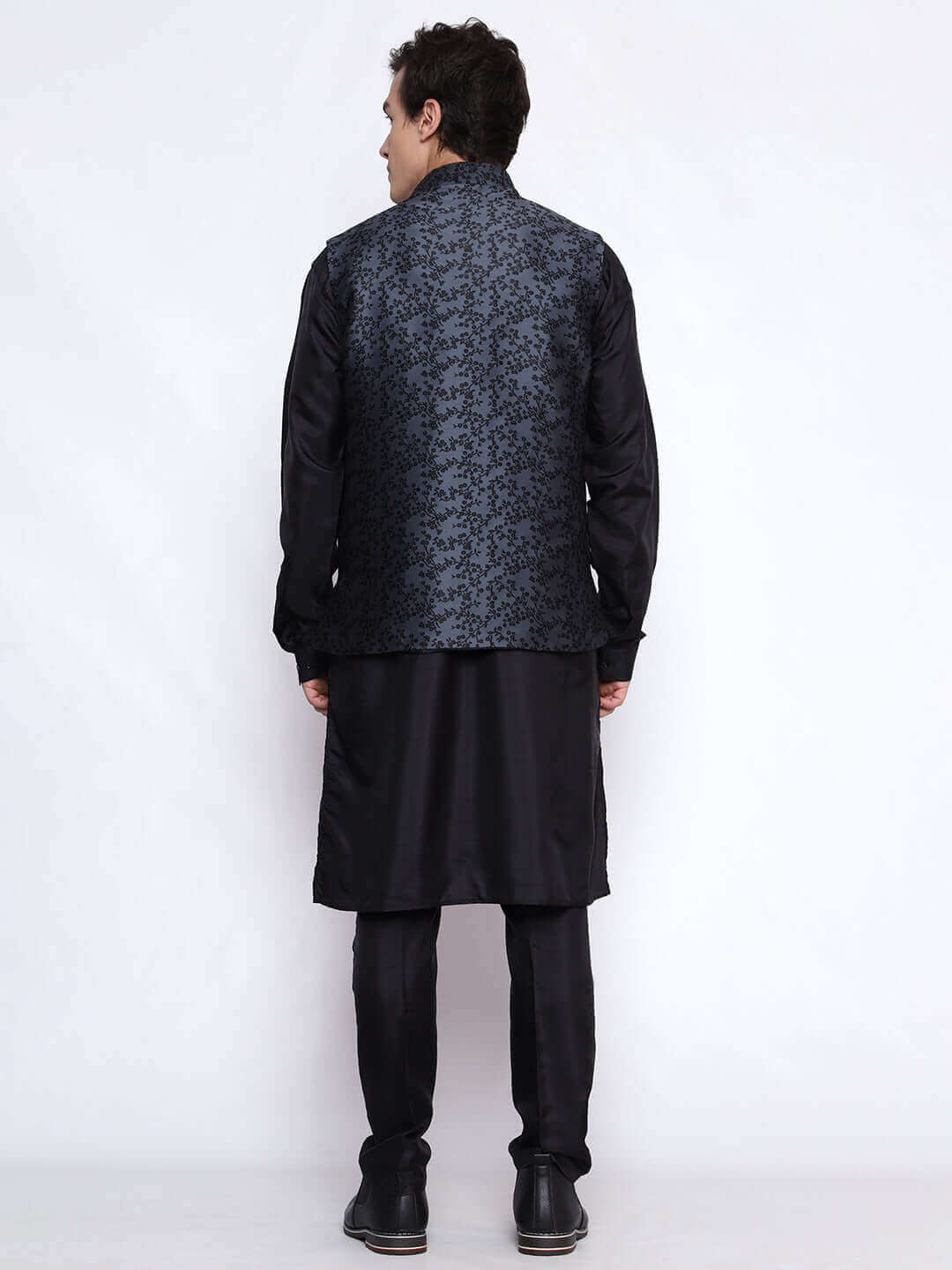 Black kurta with grey nehru jacket for men which is made up of jacquard silk and has floral embroidery on it. Shop this black designer wedding kurta jacket set for male from Crease India website.