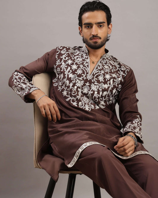 Model sitting in chair posing front in Men’s Burgundy Royale Floral Embroidered Kurta by Crease India
