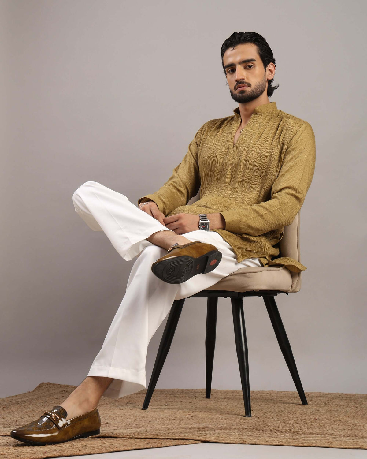 Model sitting in chair posing front in Men’s Mustard Gold V-Neck Pleated Party Wear Kurta by Crease India