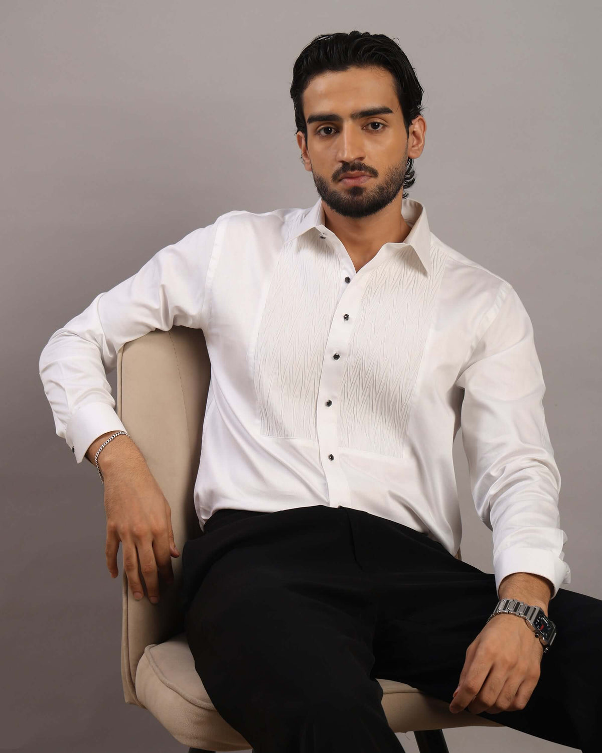 Model sitting in chair posing front in Men’s Ripple White Formal Tuxedo Shirt by Crease India