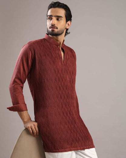 Model posing to his right in Men’s Rust Red V-Neck Pleated Party Wear Kurta by Crease India